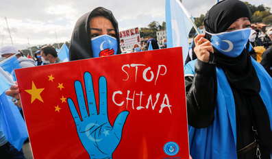 Ethnic Uighur demonstrators take part in a protest against China